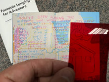 Load image into Gallery viewer, a hand holding a colored gel in front of a booklet

